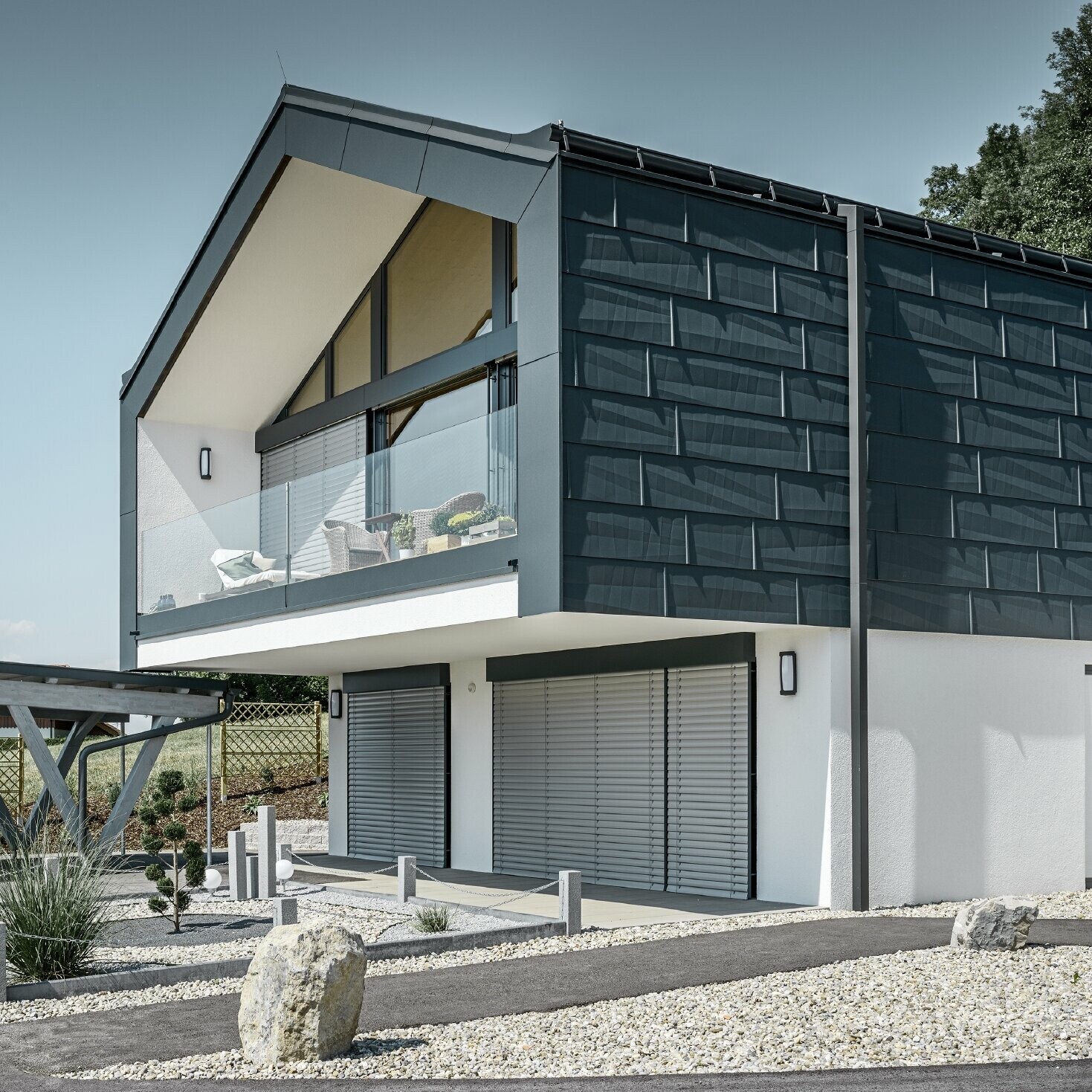 Modern apartment building with a large glass front, roof and façade were clad in the PREFA roof and façade panel FX.12 in anthracite