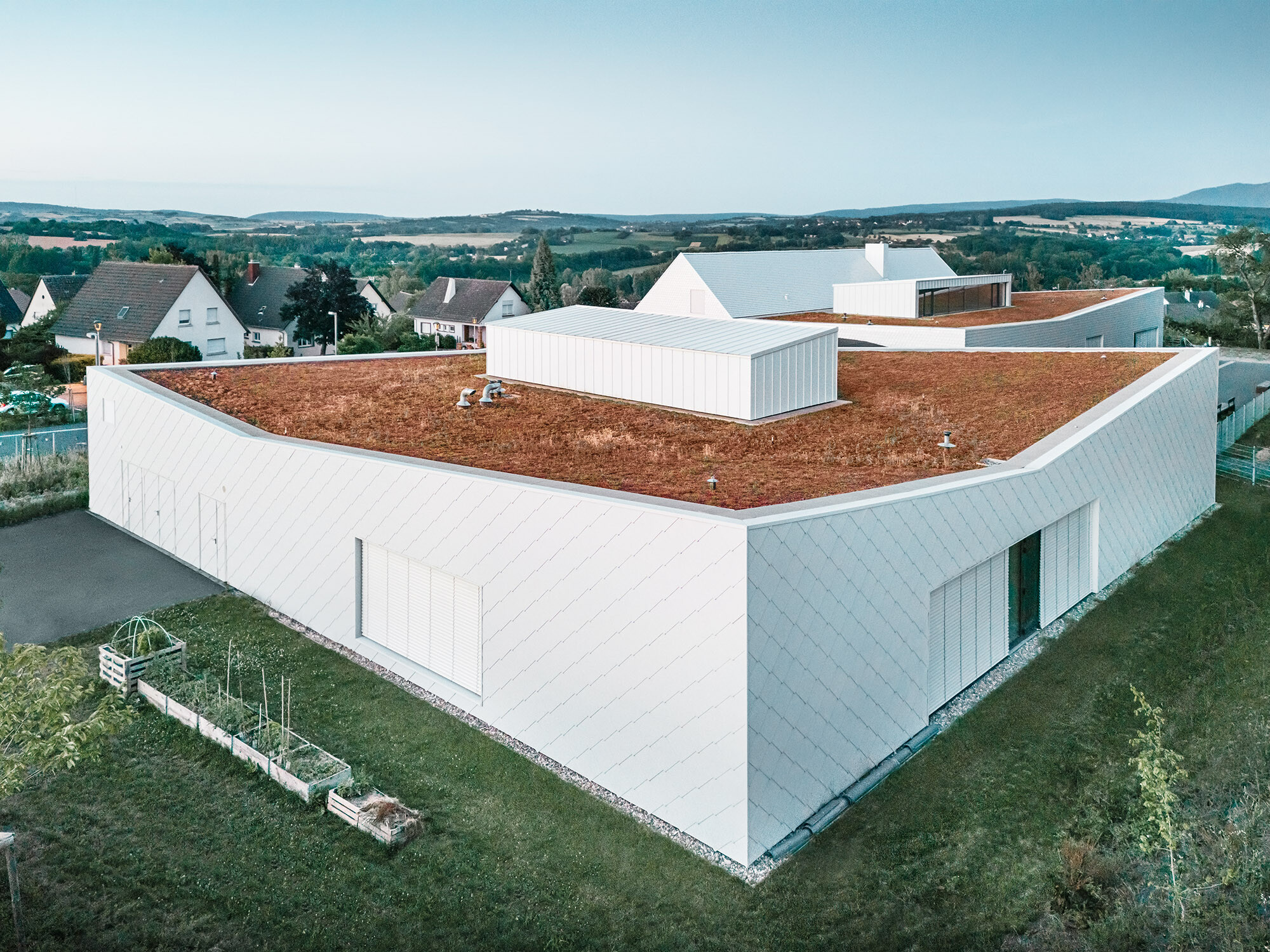 The daycare centre and its immediate surroundings from a lateral bird's eye view.