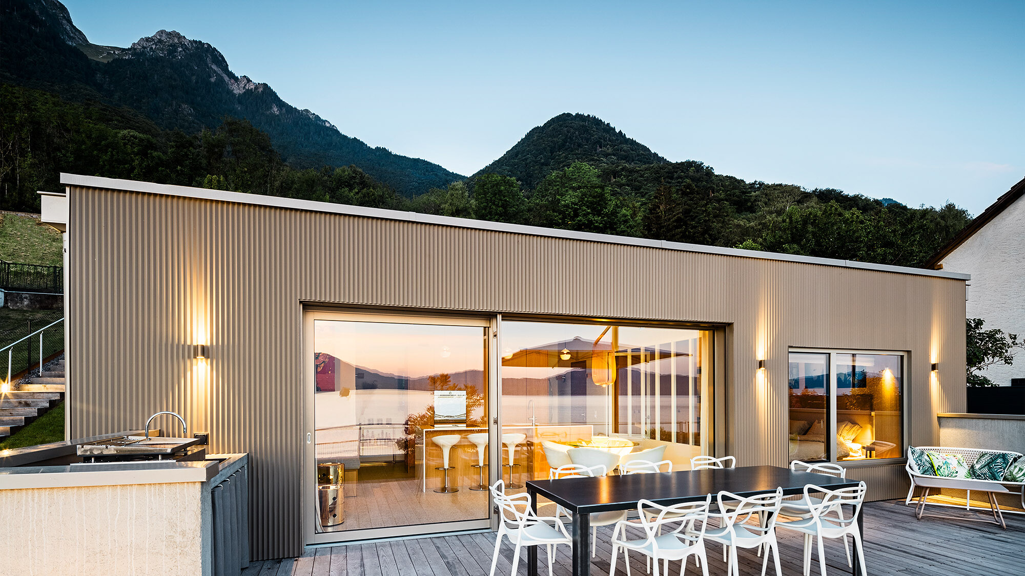 View of the terrace and part of the building's interior in the evening.