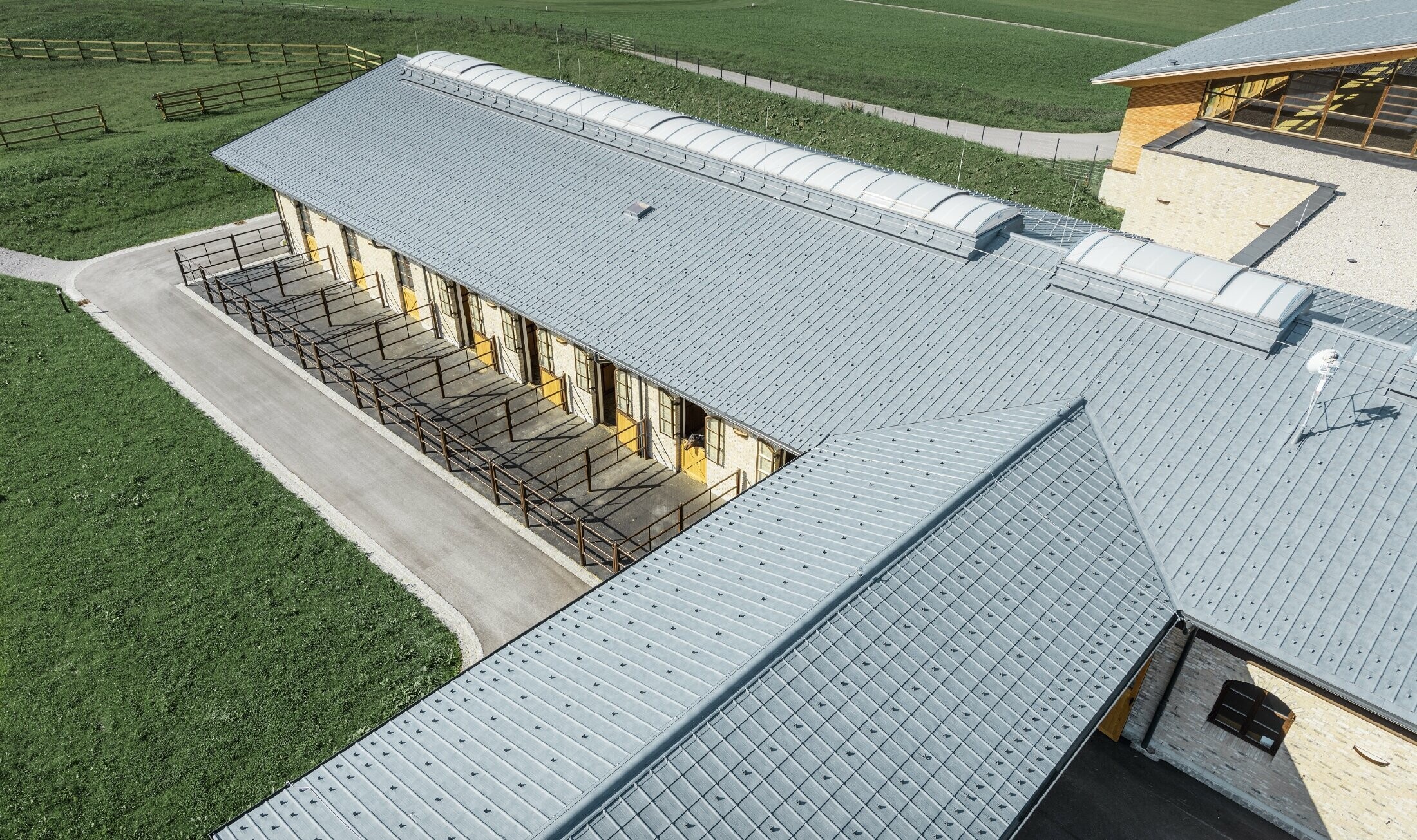Aerial view of the stud farm in Thalgau. The riding arena is covered with the PREFA roof tile in stone grey.