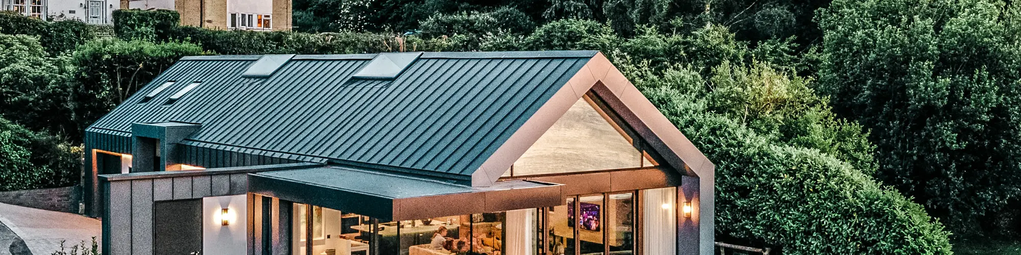 Side view of the bungalow by designed by Mitchell Evans Architects in Cowes on the Isle of Wight. The terrace, the generously glazed front and the evenly laid Prefalz trays are in clear view.