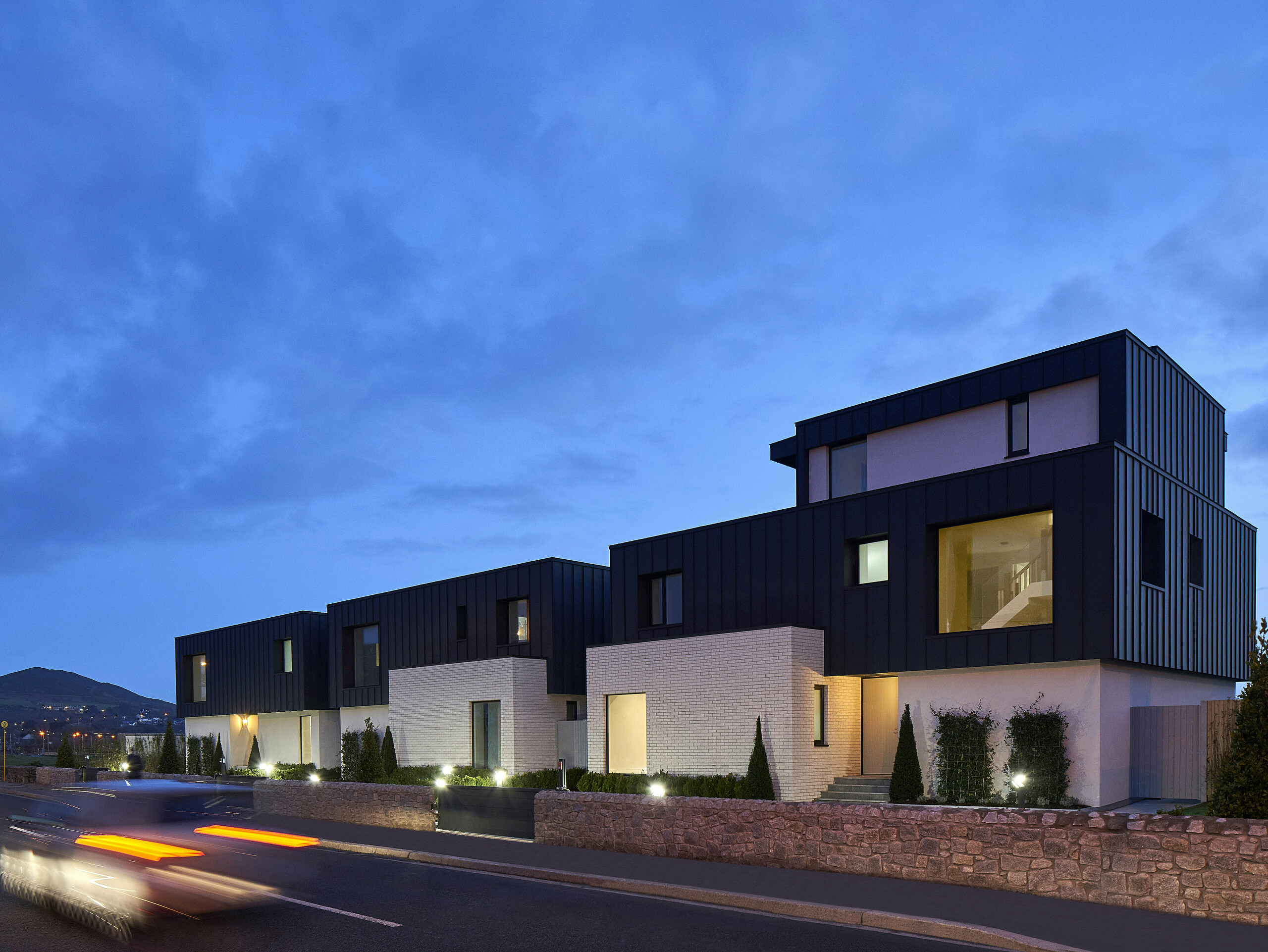 Picture of the residential houses with PREFALZ in the colour P.10 anthracite in the evening.