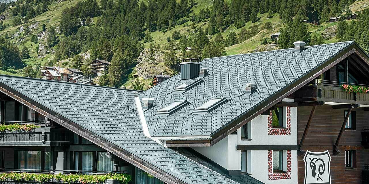 Hotel Alpenhof in Zermatt (Switzerland) with the Matterhorn mountain in the background, balconies, dark wooden façades and a PREFA aluminium roof in anthracite