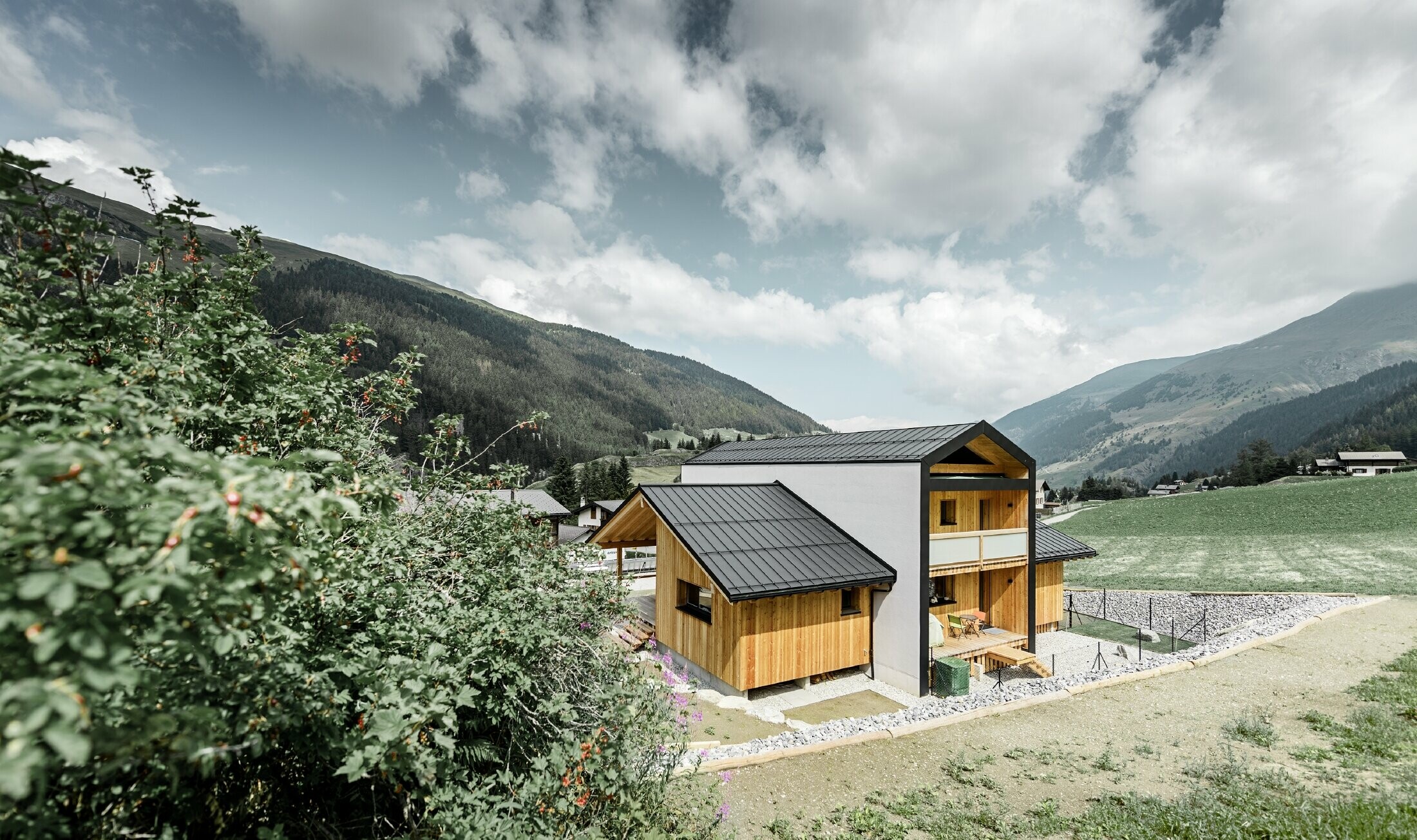 This detached house gives the impression of 2 houses positioned on top of one another at a 90° angle. The roof is clad in black Prefalz and the façade is partly in wood.