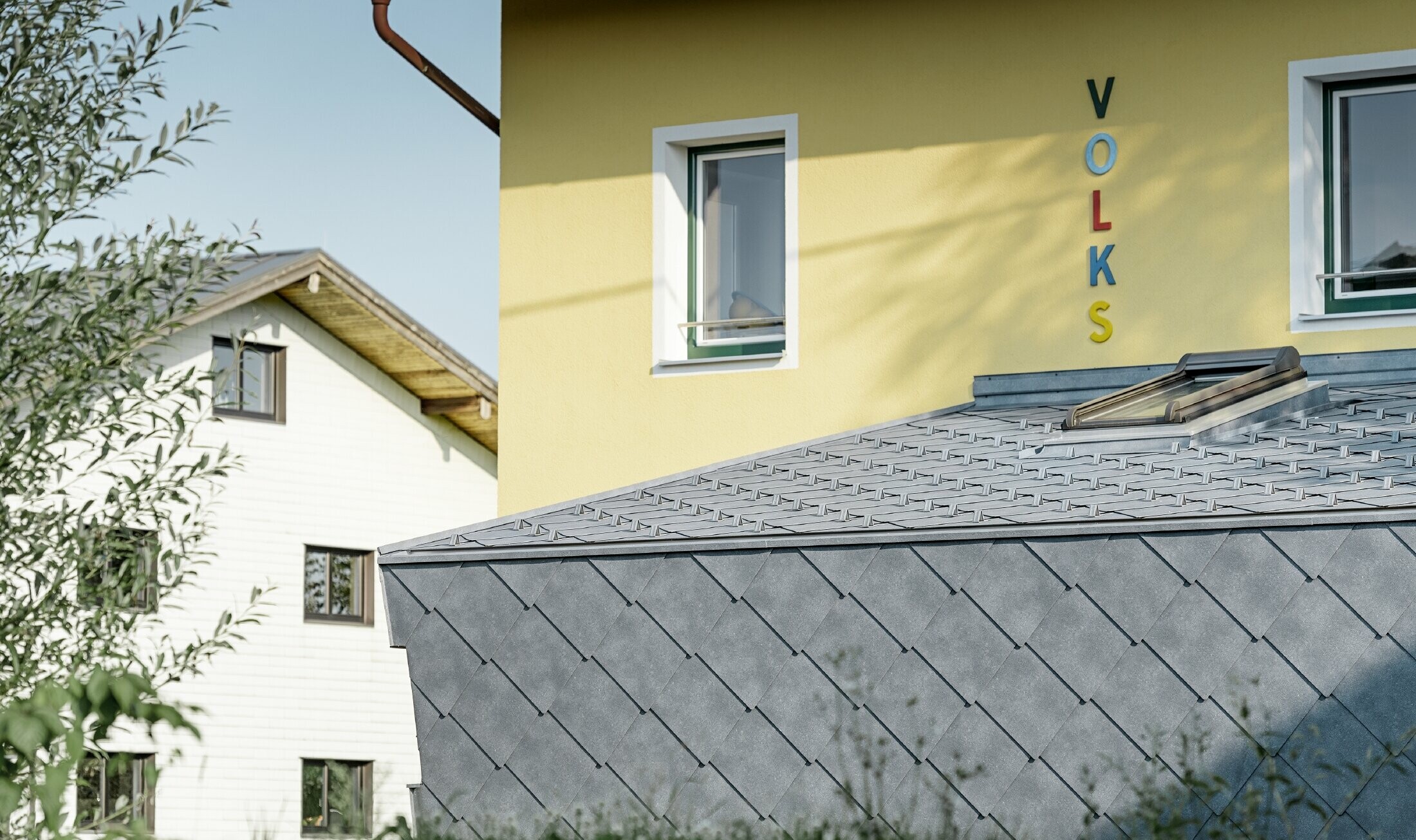 Primary school annex building covered with a PREFA aluminium roof and façade tiles in stone grey