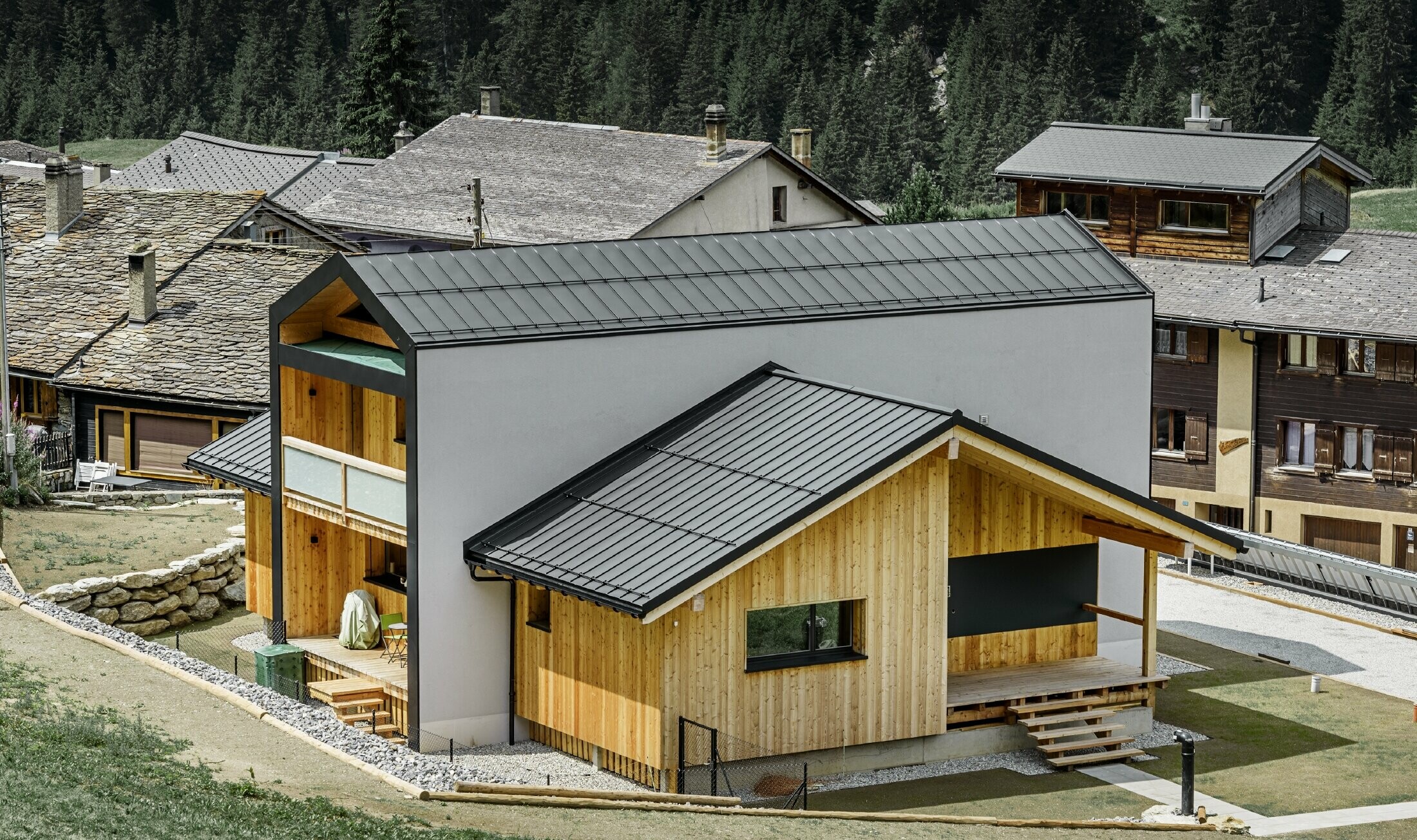 This detached house gives the impression of 2 houses positioned on top of one another at a 90° angle. The roof is clad in black Prefalz and the façade is partly in wood.