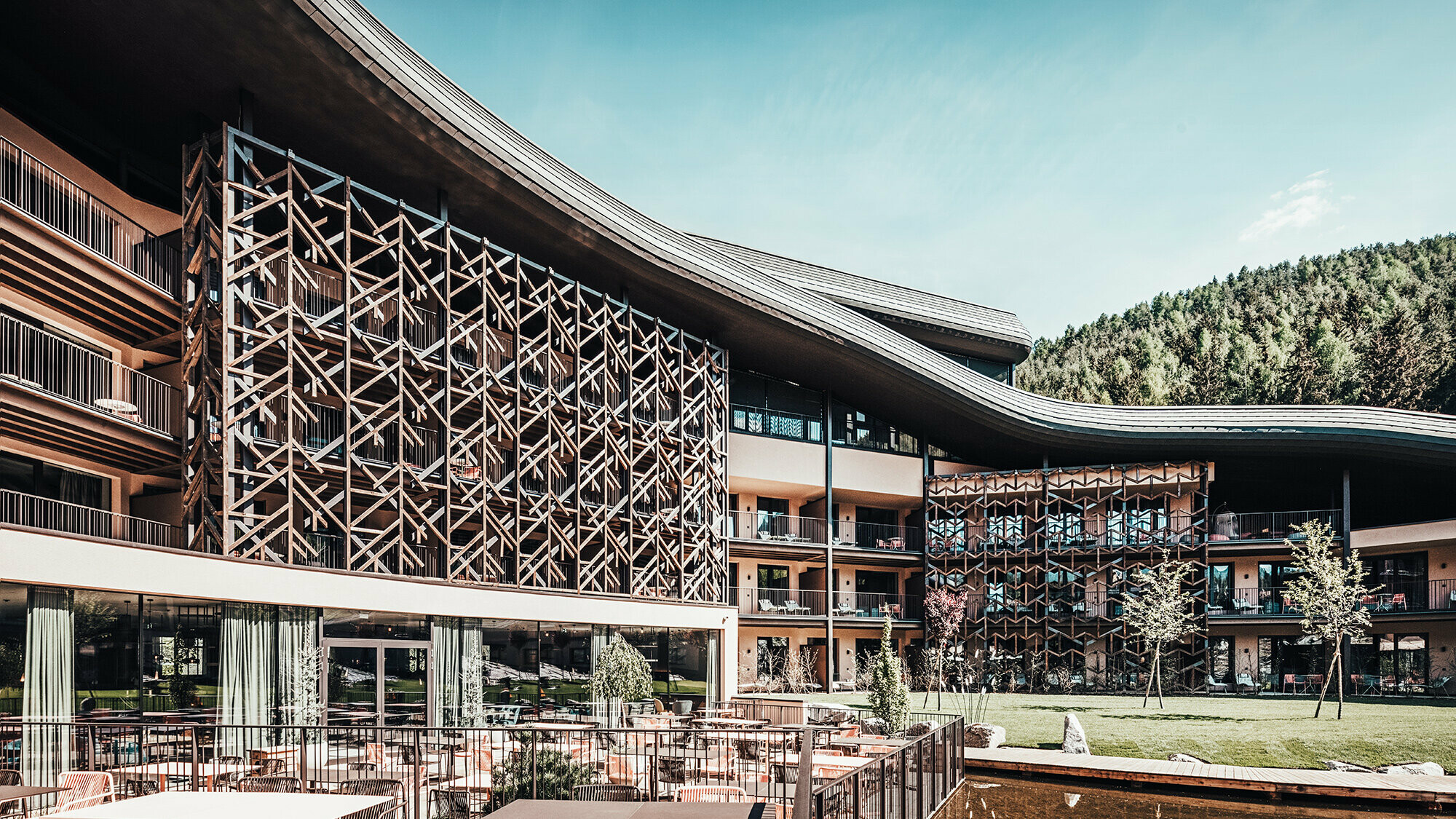 Exterior view of the luxury hotel covered in PREFA façade shingles. The roof wave runs across the entire building.