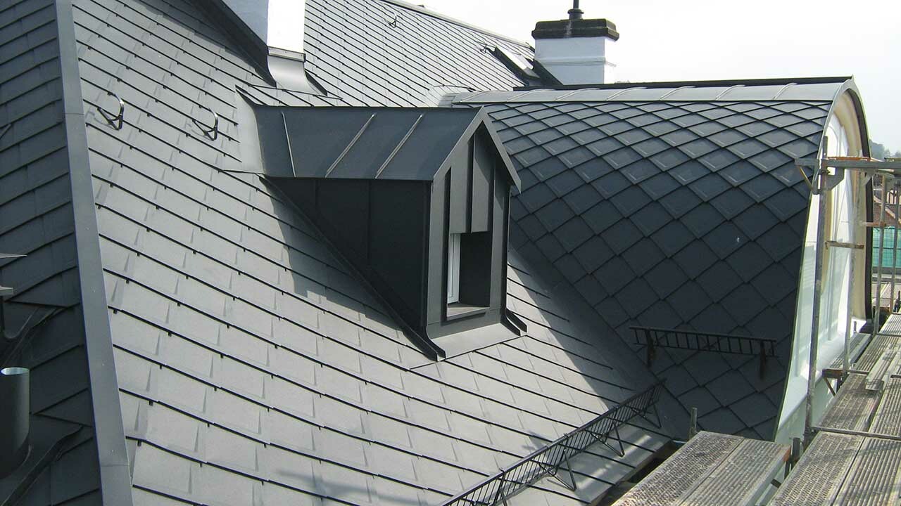 Close-up of a hotel in Bad Kissingen with elaborate dormers after renovation, clad with PREFA rhomboid roof tiles.