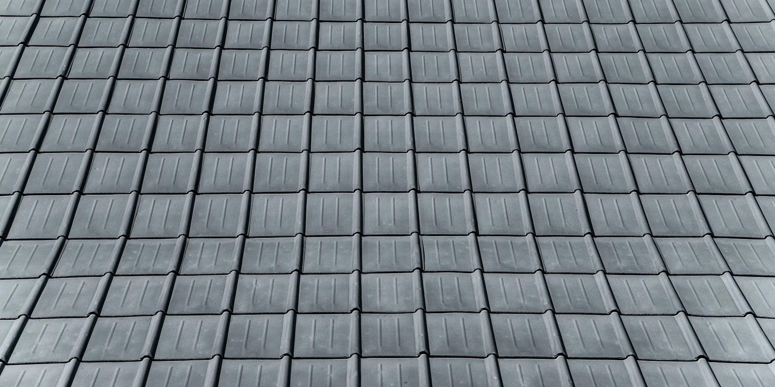 Detailaufnahme des mit robusten PREFA Dachplatten eingedeckten Einfamilienhauses in Tarvis, Italien. Das Bild zeigt das langlebige Aluminiumdach, das seit 1972 zuverlässig den alpinen Witterungsbedingungen trotzt und durch sein zeitloses Design besticht.