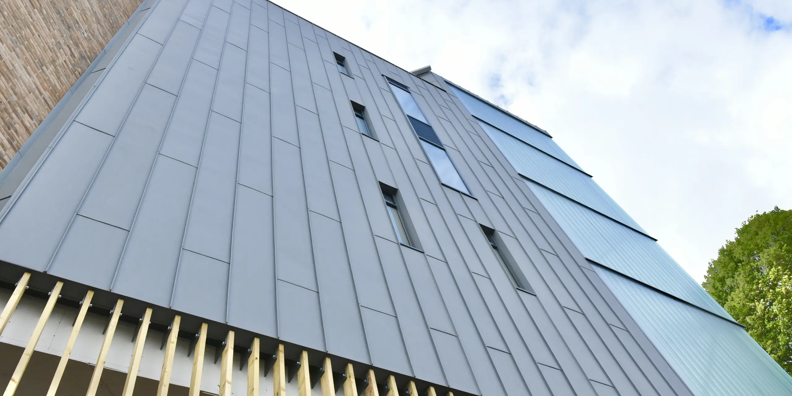 Detailed view of the PREFALZ standing seam cladding in patina grey at North Regional College. The precise workmanship of the aluminium underlines the sustainable and modern character of the façade, which blends harmoniously into the overall architecture.