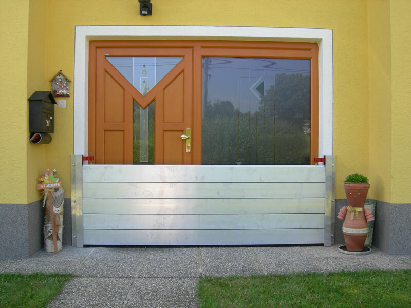 Front door of a family home with the modern PREFA flood protection system 