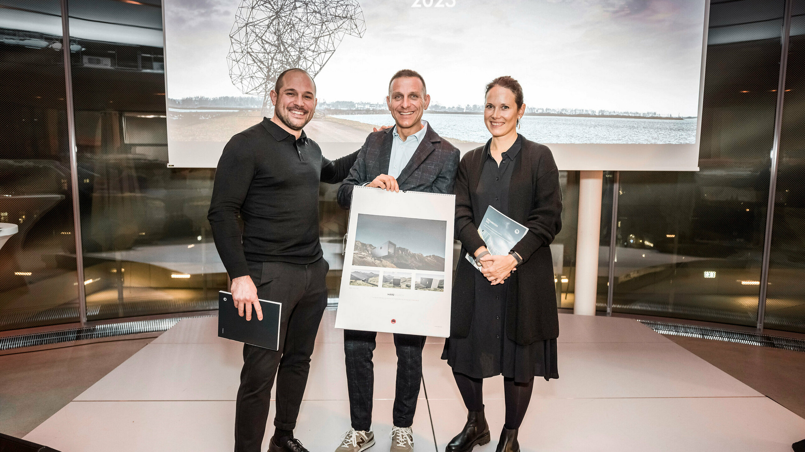 Part of the architecture collective BCW collective with installer Luca Frutaz, who is holding the calendar in his hand.