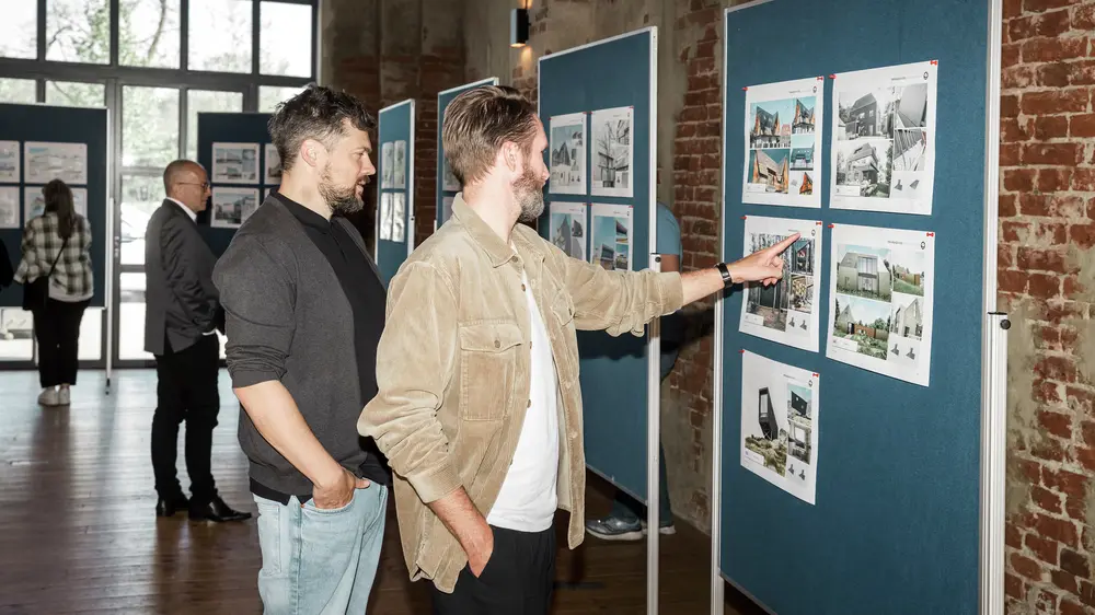 Two vitsitors looking at a board with PREFARENZEN objects