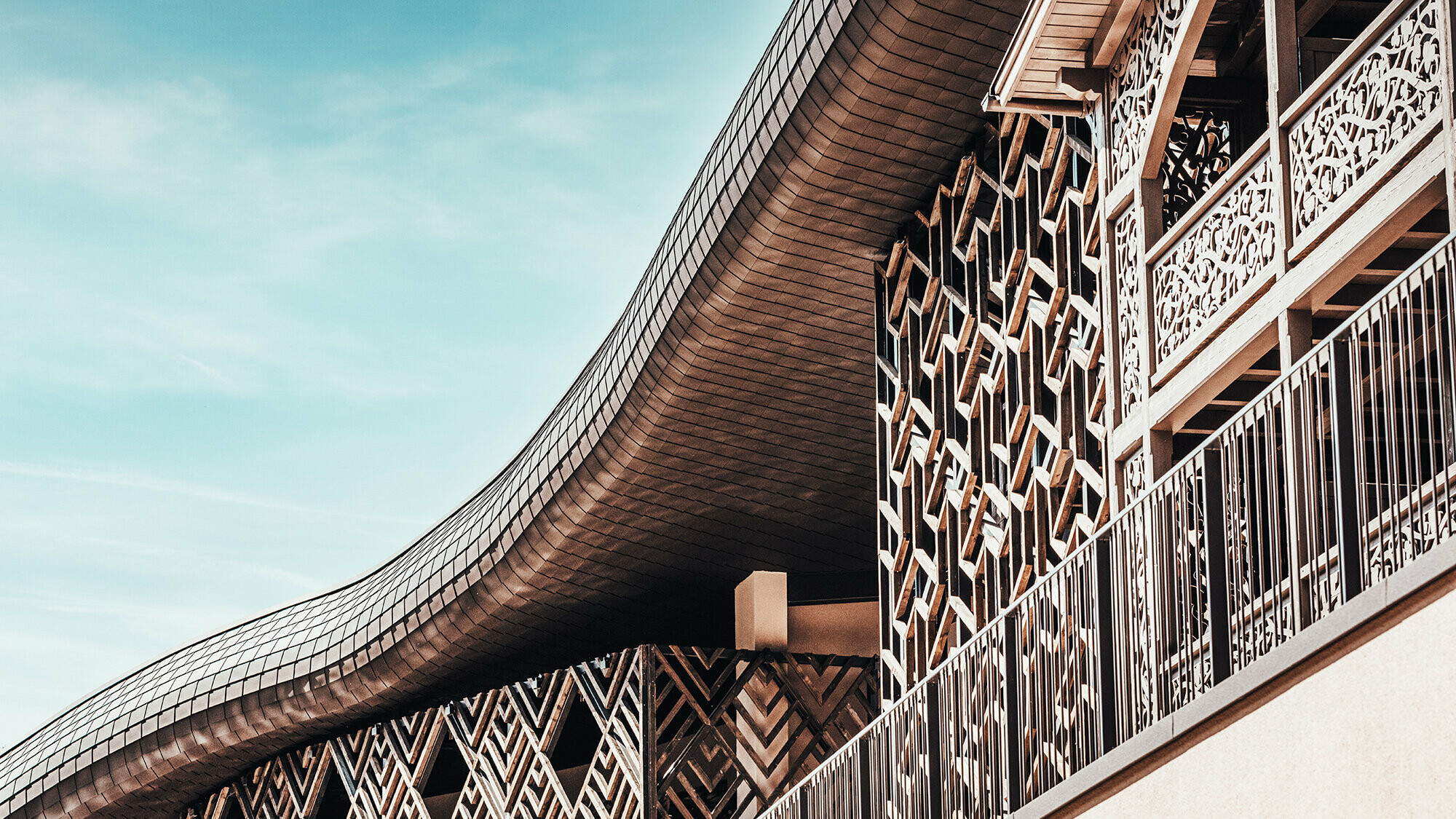 A picture of the exterior of the Falkensteiner Hotel. The roof wave is covered in PREFA facade shingles in P.10 brown and is particularly visible here.