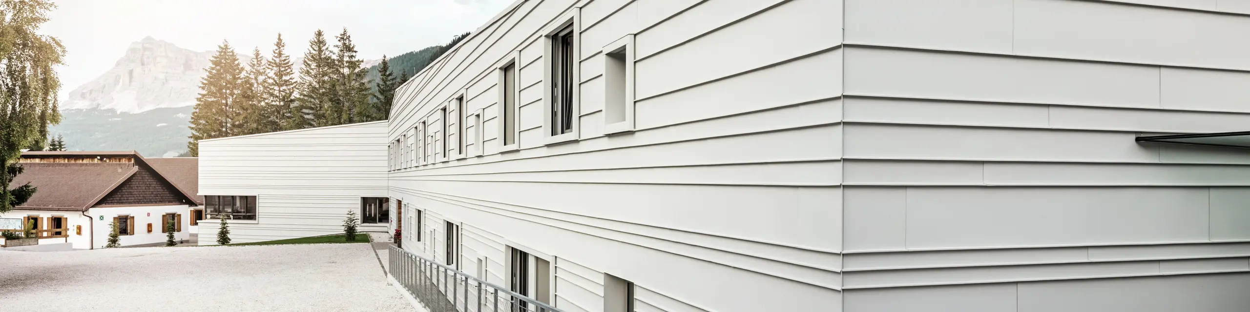 The modern architecture of the Tempesti barracks makes a striking statement with PREFALZ in the colour P.10 PREFA white. The horizontal aluminium panels create a clear structure. The light colour reflects light, which improves the microclimate in the alpine environment.