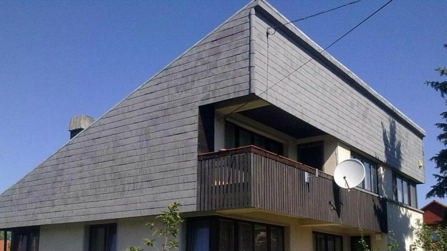 Detached house with single-pitch roof before renovation of façade with PREFA façade shingles