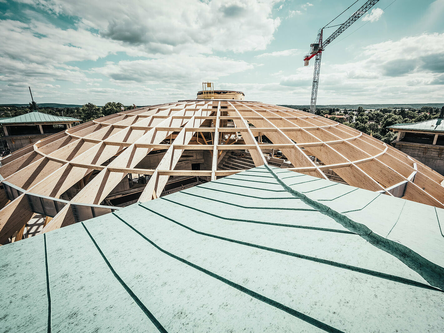 On the picture you can see the biggest laminated cupola in Hungary in the process of completion. In the foreground is the Prefalz roof in patina green. 