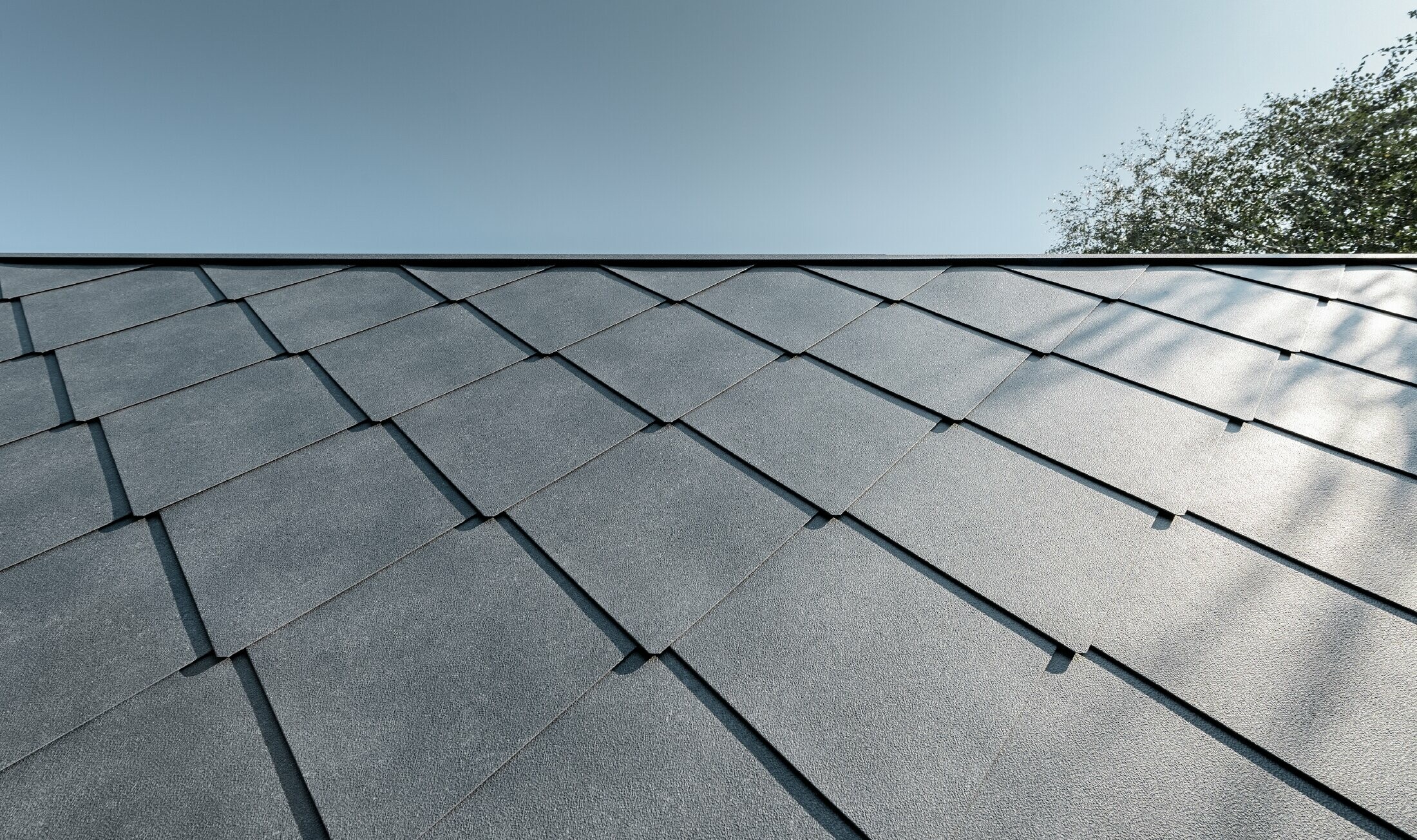 Primary school annex building covered with a PREFA aluminium roof and façade tiles in stone grey