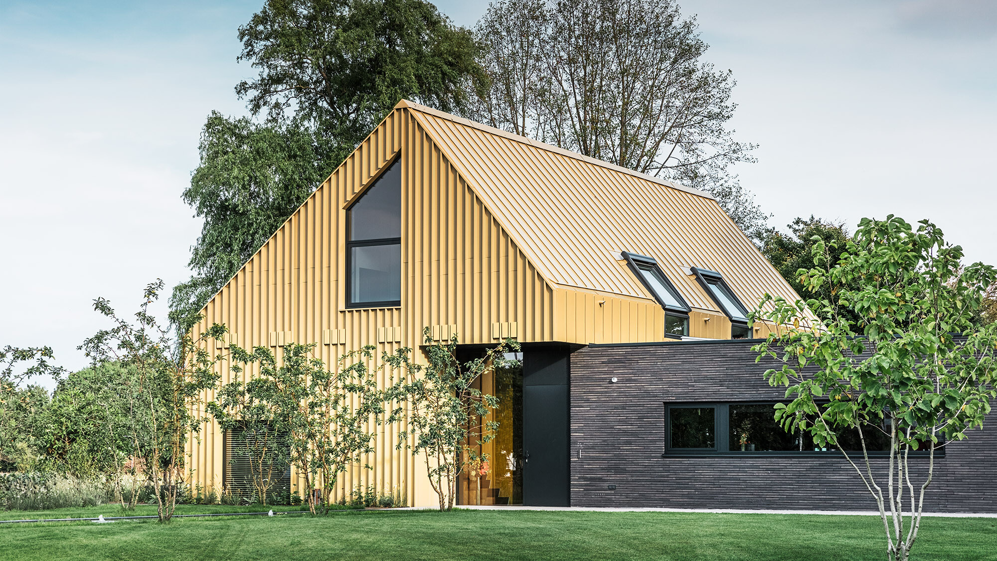 The house from a lateral normal perspective: an elongated low building pushes into the side of the main house.