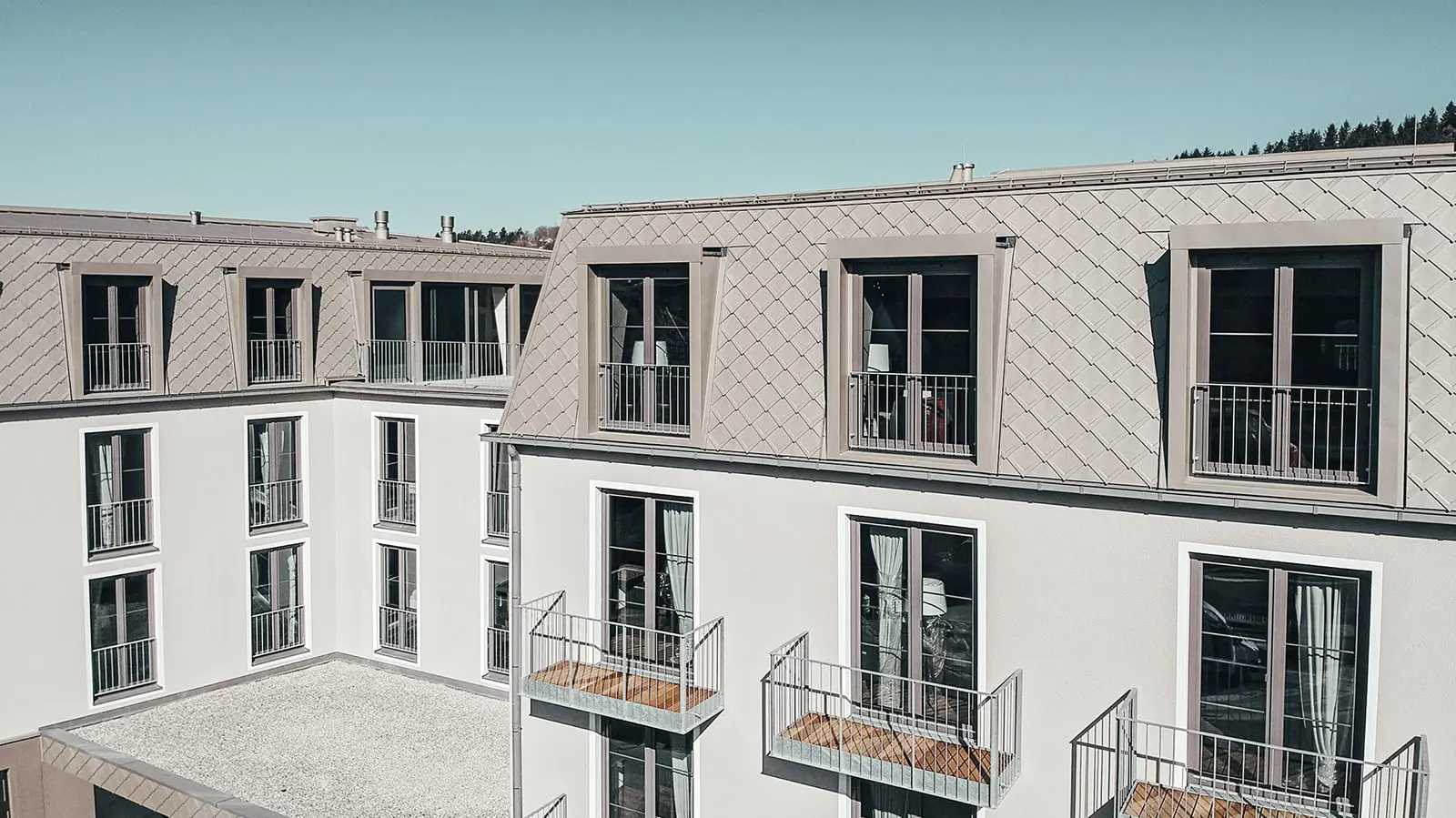 Side view of the rhomboid façade tiles from PREFA in the colour bronze.