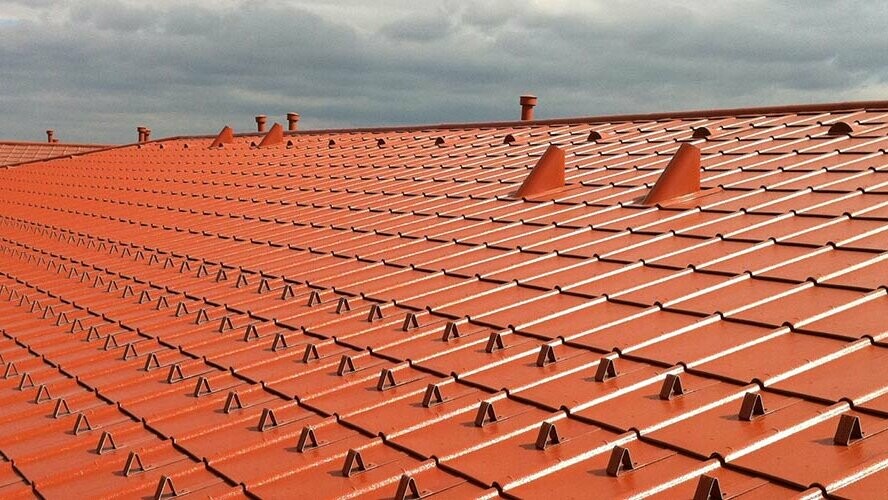 Close-up of a PREFA tile-effect aluminium roof - PREFA roof tiles in brick red with snow guards