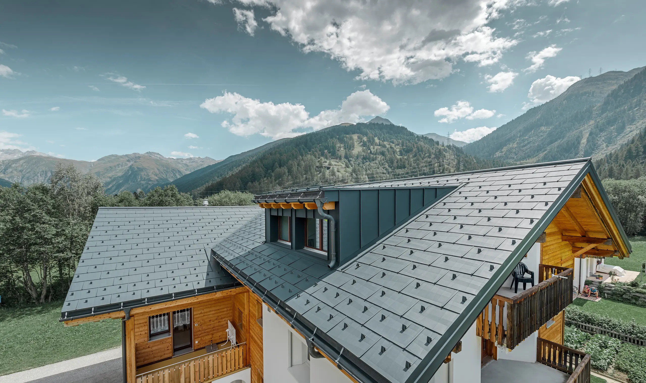 Newly refurbished residential building with gabled roof and dormer. The roof was refurbished with the PREFA FX.12 roof panel in anthracite.