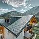 Newly refurbished residential building with gabled roof and dormer. The roof was refurbished with the PREFA FX.12 roof panel in anthracite.