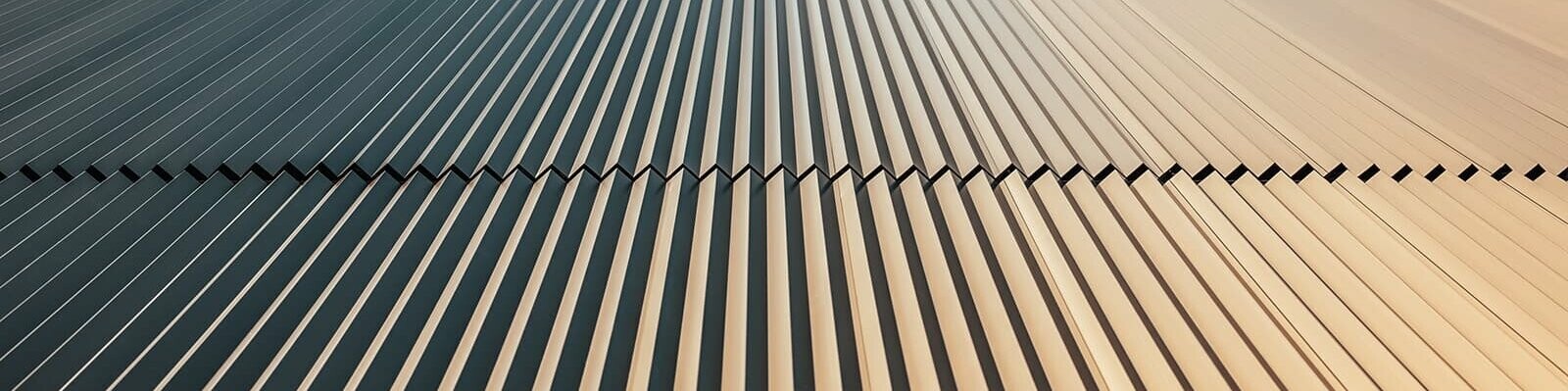 Worm´s eye view of the PREFA façade which was covered with the serrated profile in bronze. The view is up to the sky.