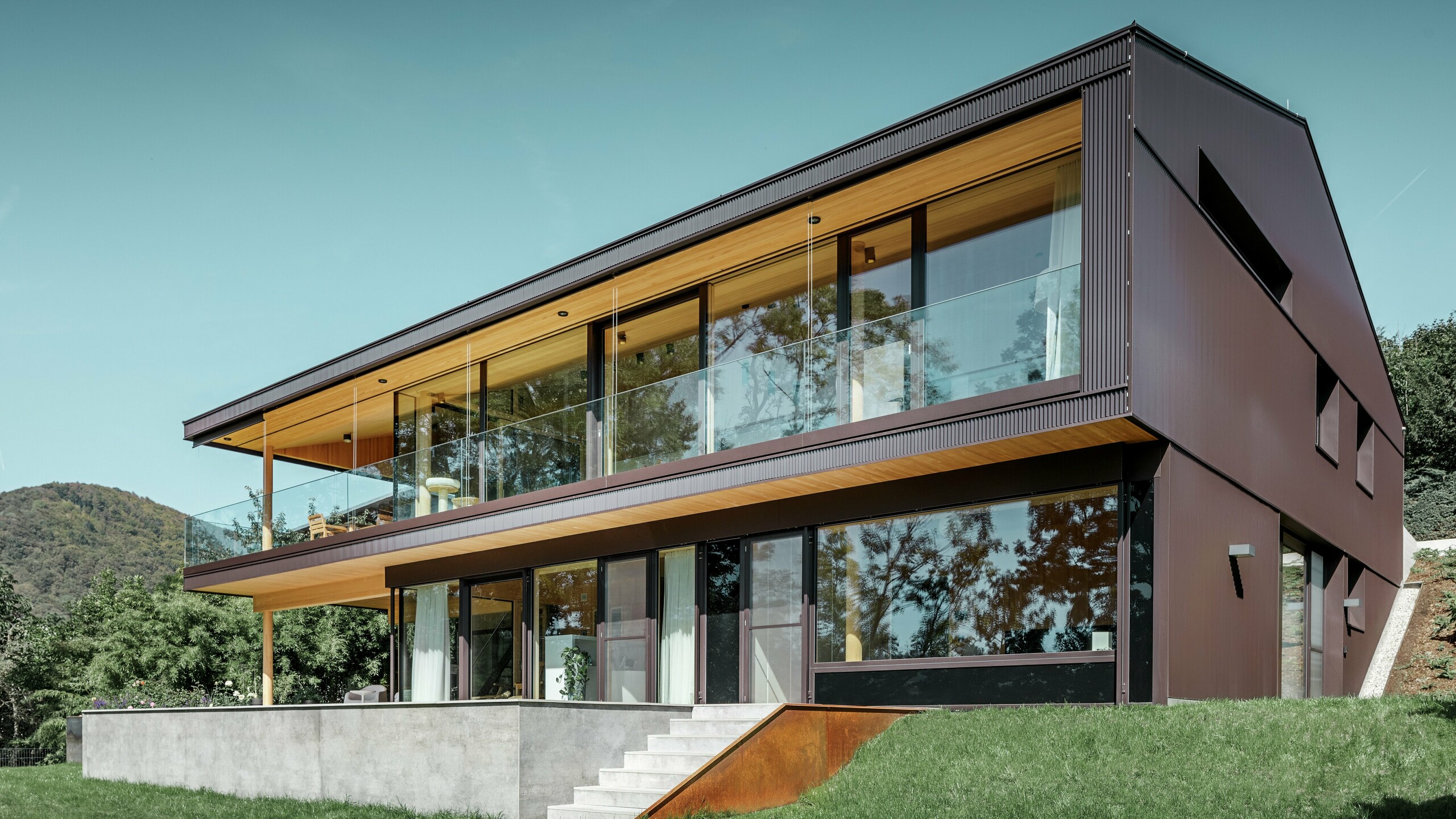 Modern detached house with large windows on the garden side; the façade was clad in the PREFA zig-zag profile in dark brown.