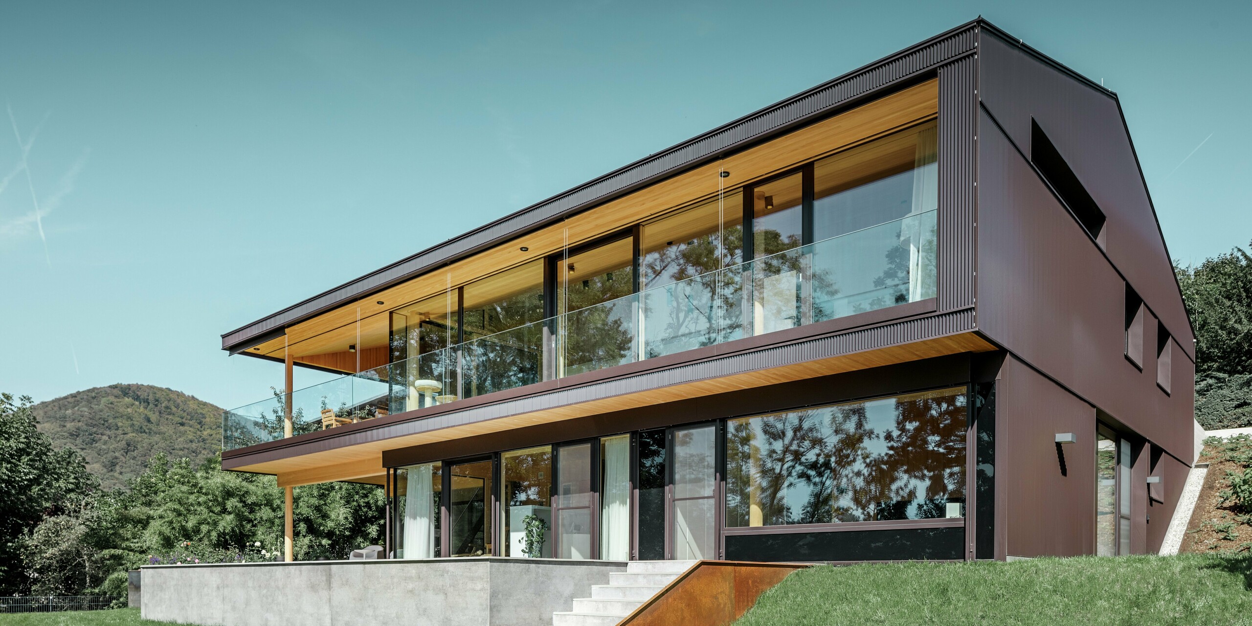 Modern detached house with large windows on the garden side; the façade was clad in the PREFA zig-zag profile in dark brown.