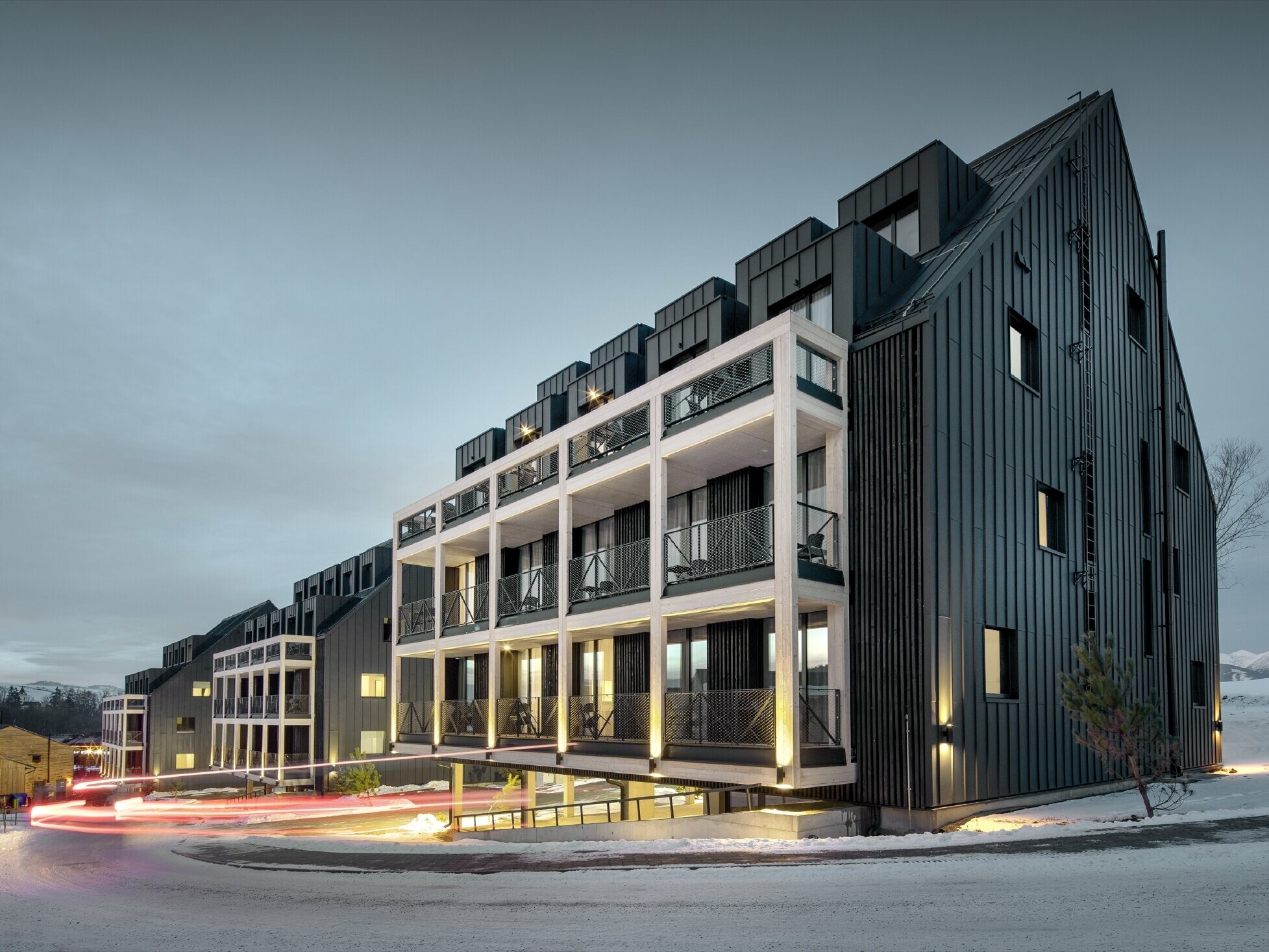 Ski resort in Slovakia with balconies and dormers, the façade is clad with PREFALZ in anthracite, just like the gable roof, snow-covered surroundings