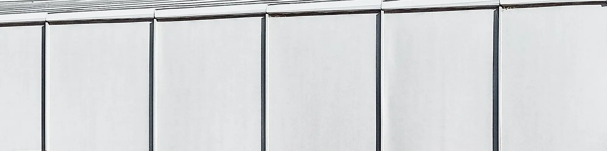 The house's matt grey aluminium envelope with its regular rhythm from up close.