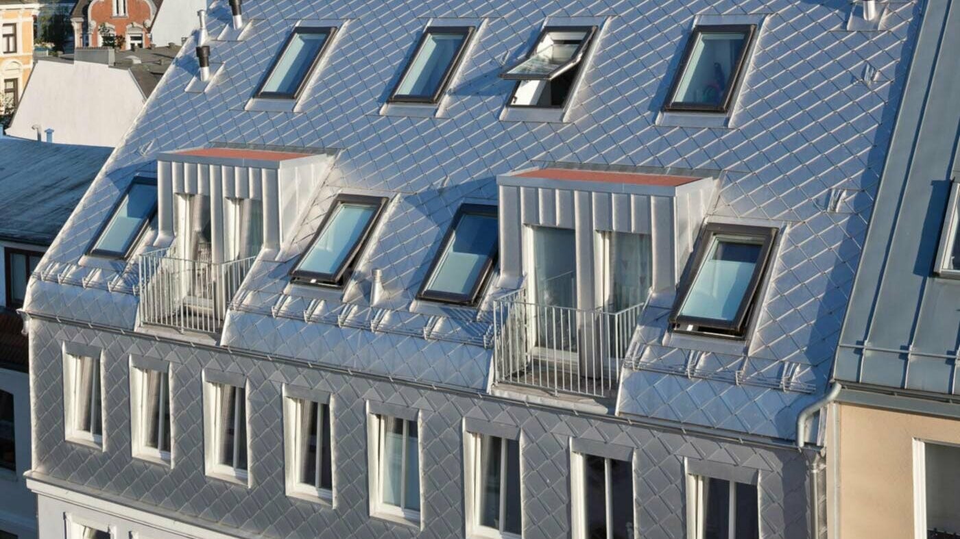 Plain aluminium shed roof for attic extension with many skylights