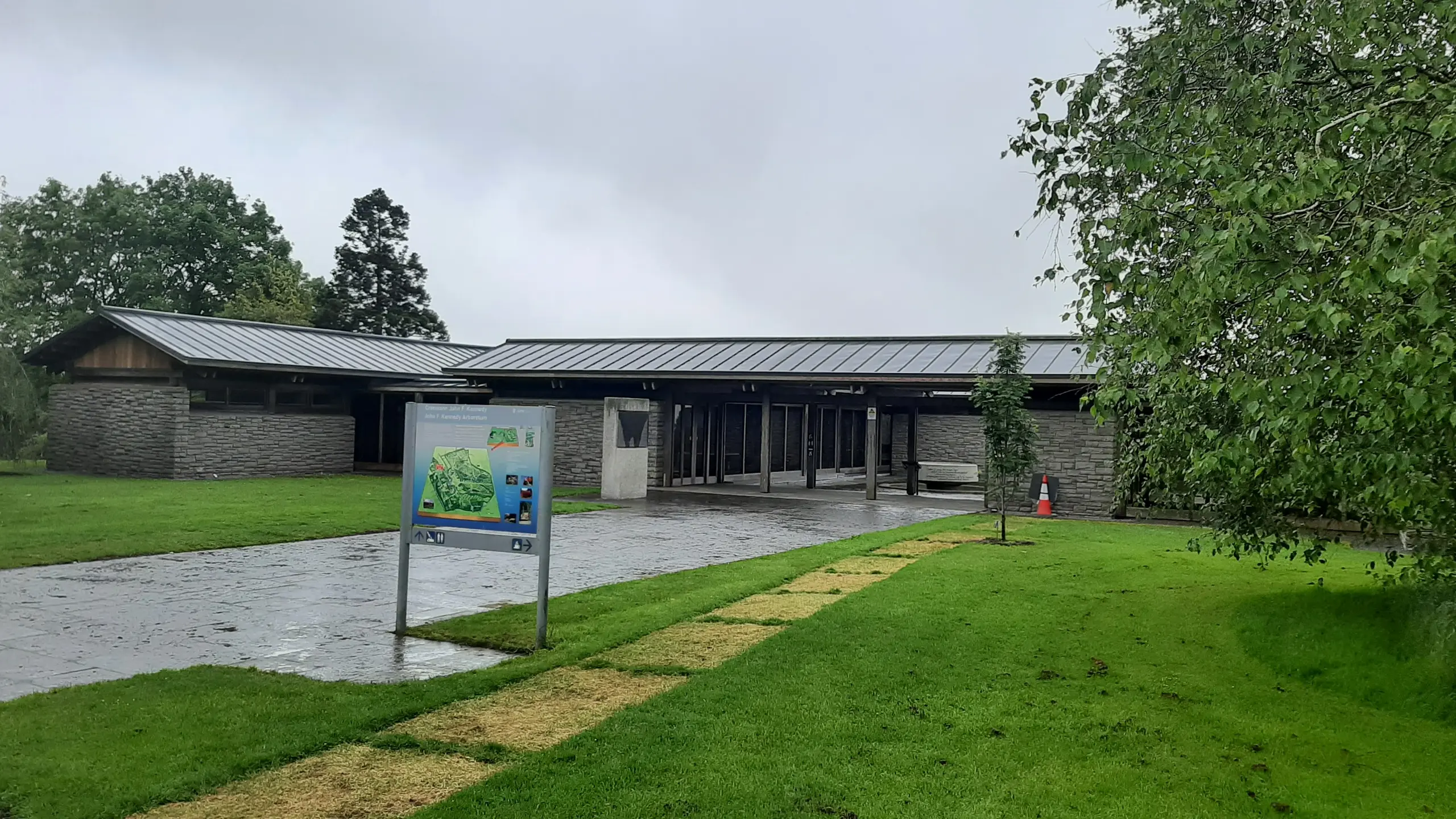 Picture of the new roof of the visitor center with PREFALZ in the colour P.10 dark grey. Around the vistor center you can see a sign and a tree.