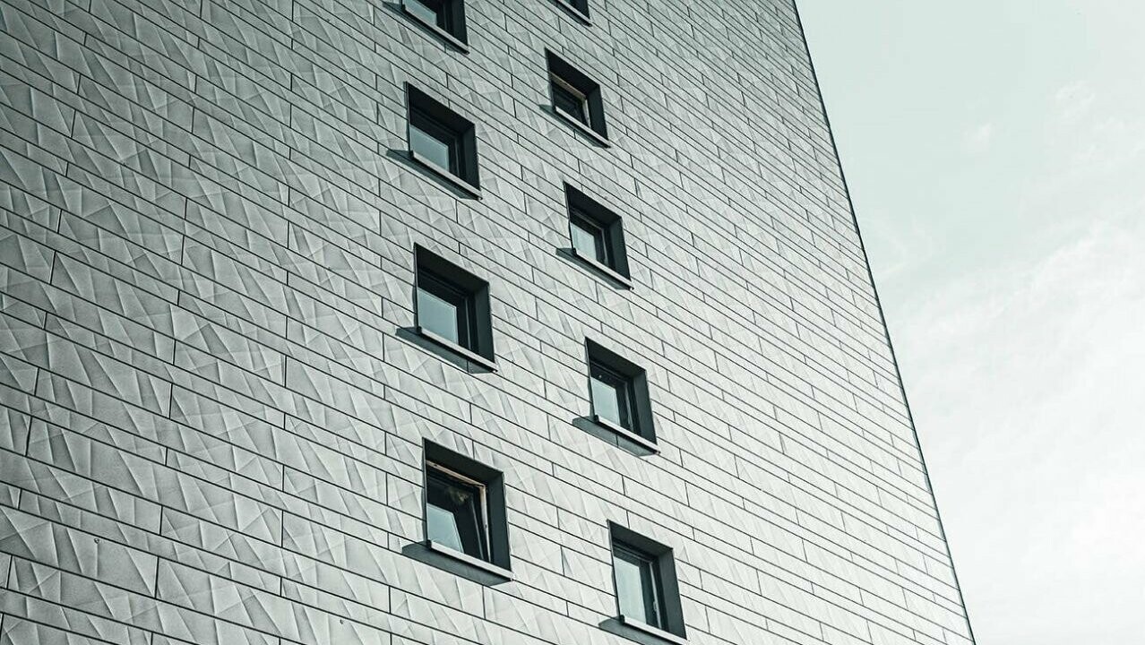 A close-up of the PREFA façade system siding.X in the colour P.10 light grey. The high-rise in Erftstadt was photographed from bottom to top.