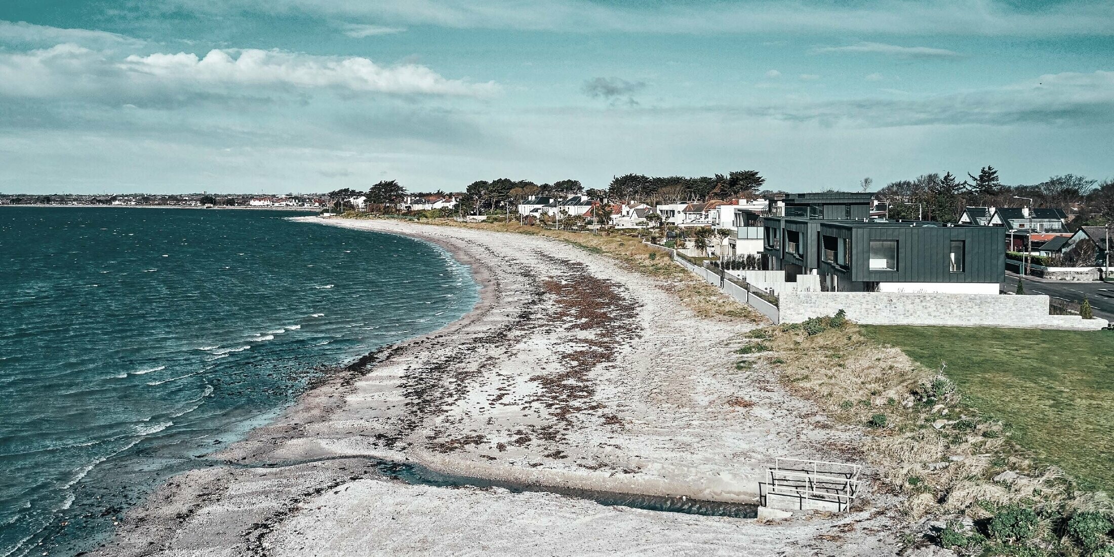 Picture of the residential houses on the beach. On the left side you can see the sea, on the right side the terraced houses can be seen.