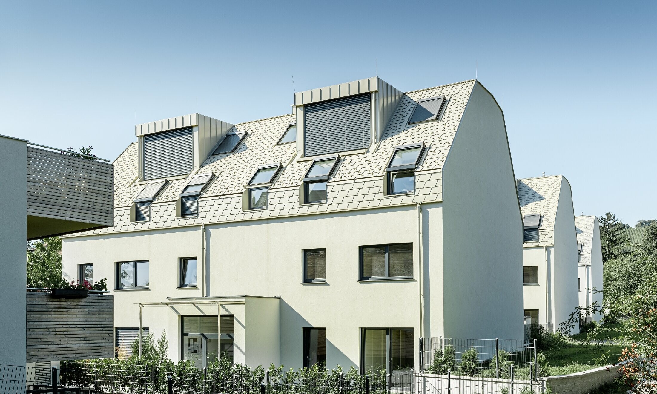 New residential complex with a large aluminium roof surface and a host of roof windows