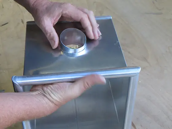 Push the outlet with bonding flange through the PREFA leader head from the inside (the longest side of the PREFA outlet should be at the bottom).