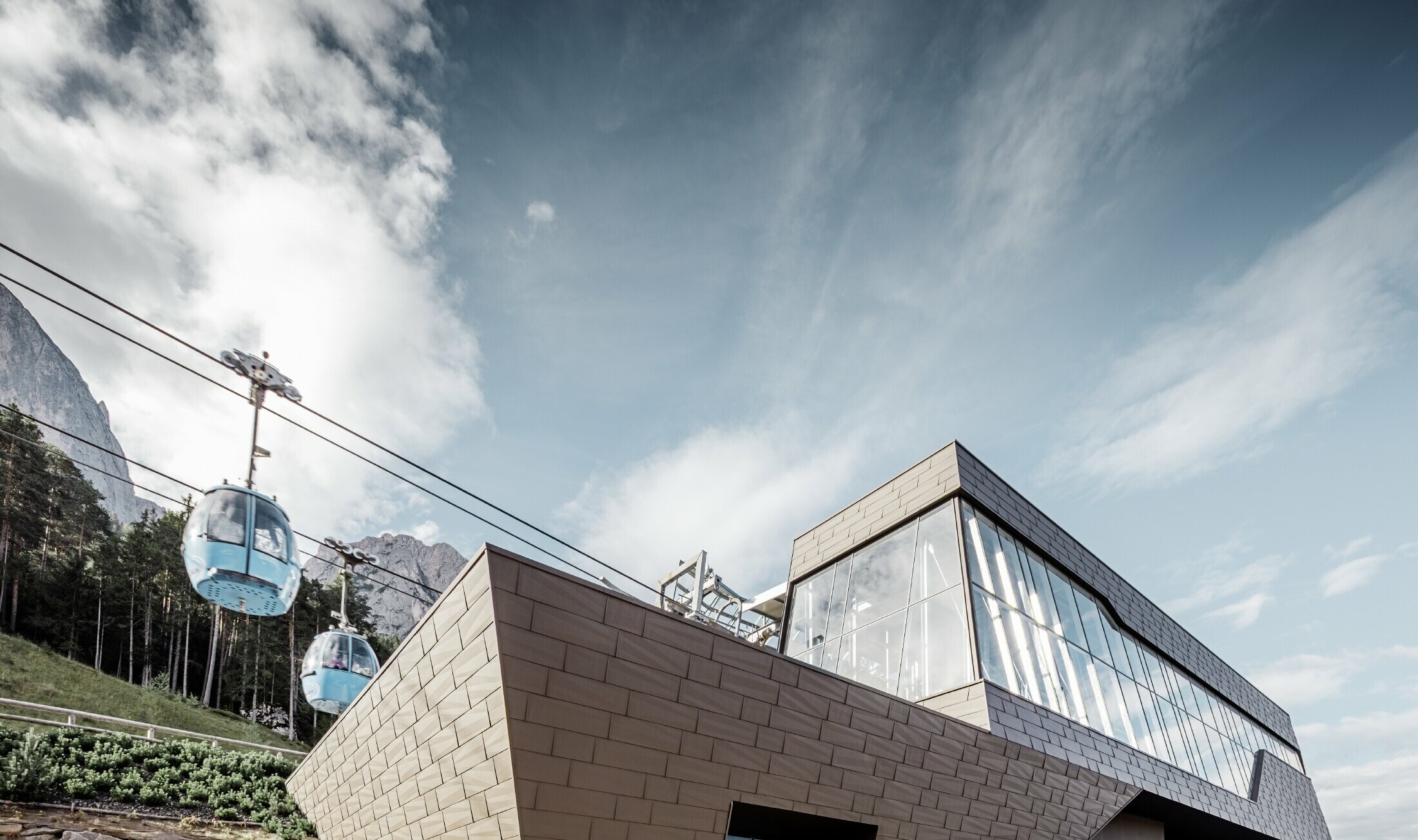 Redesigned valley station for the Seiser Al shuttle service in Italy, resembling the Dolomites in the background with irregular edges and surfaces, and an aluminium façade in brown by PREFA