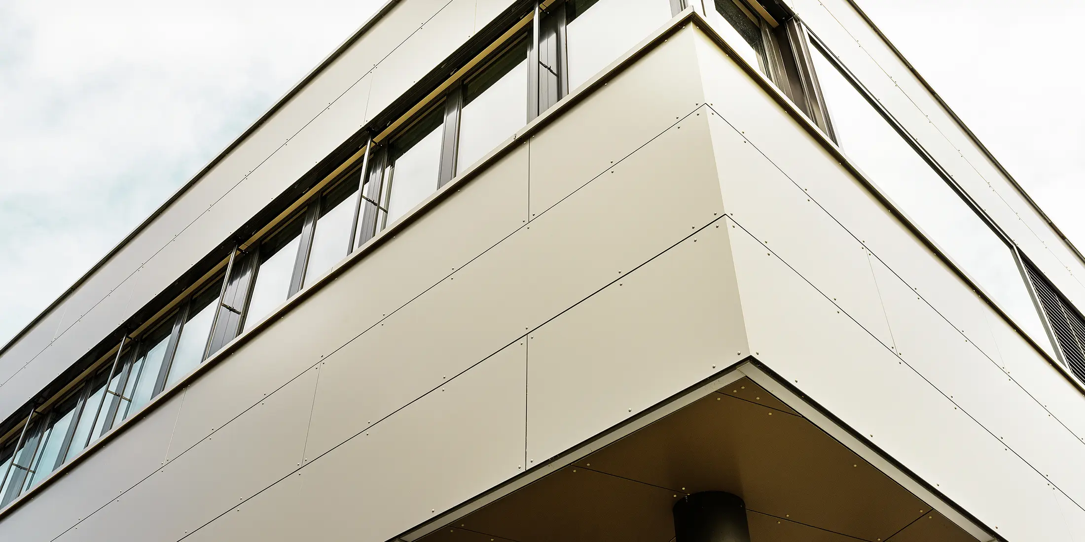 Modern annex building accommodating Guggisberg’s workshop and offices with PREFA aluminium composite panels in bronze