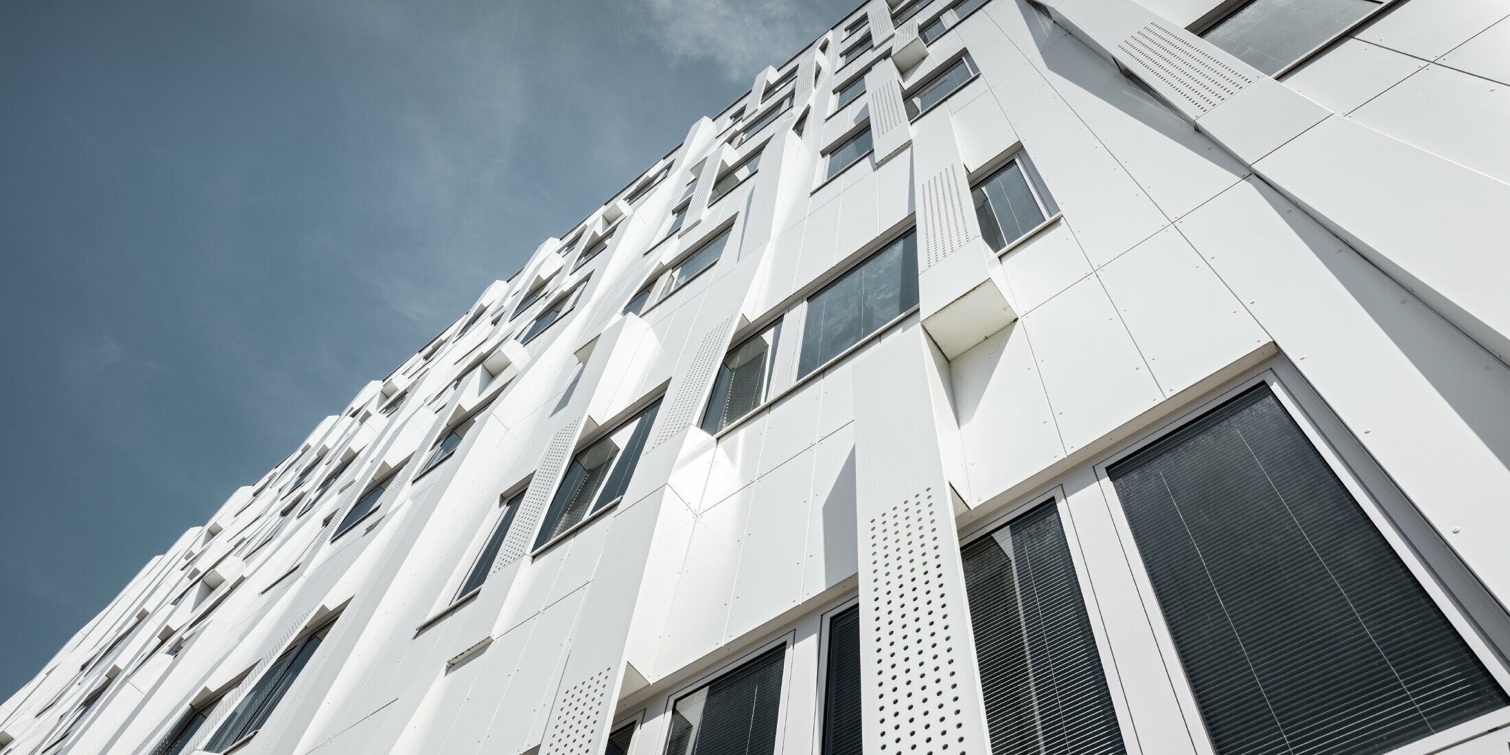 Special 3D façade, with perforated aluminium composite panel cassettes and normal PREFA composite panels in pure white, PREFA cassette façade