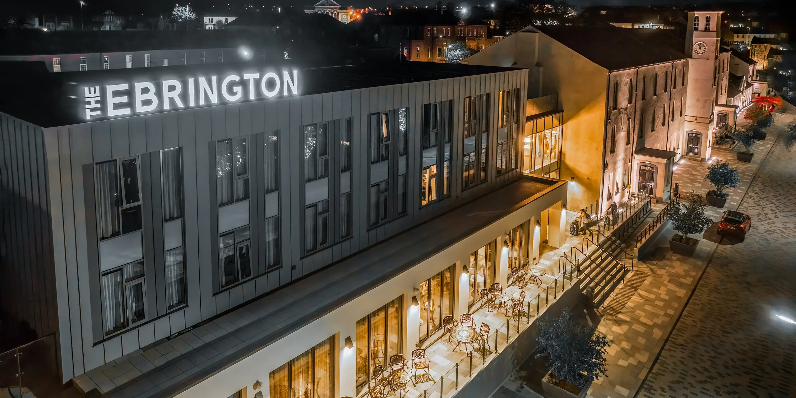 The Ebrington Hotel at night stands out with its impressive lighting in a pedestrianised area in the centre of Londonderry, Northern Ireland. The modern guest house was clad with robust PREFALZ aluminium cladding in the colours P.10 light grey and P.10 zinc grey. This high-quality sheet metal façade protects the building from the elements. The standing seam cladding also acts as a highlight in the sleek architecture.