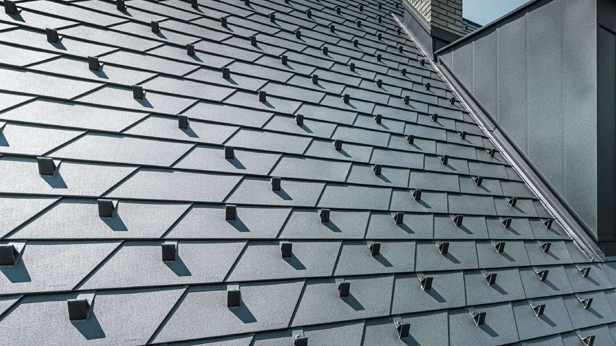 Newly renovated roof with PREFA roof shingle in P.10 Black incl. snow guards, dormer covered with PREFA aluminium