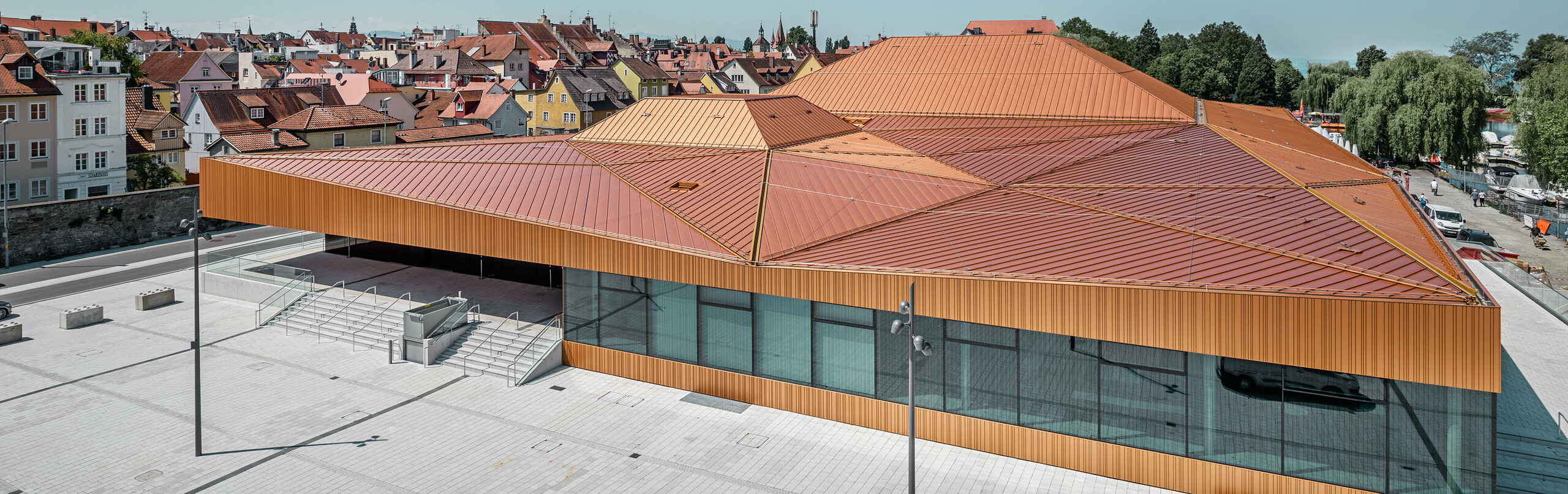 Deutsche Veranstaltungshalle mit PREFA Falzonal an Dach und Fassade in einer Sonderfarbe, ähnlich neukupfer