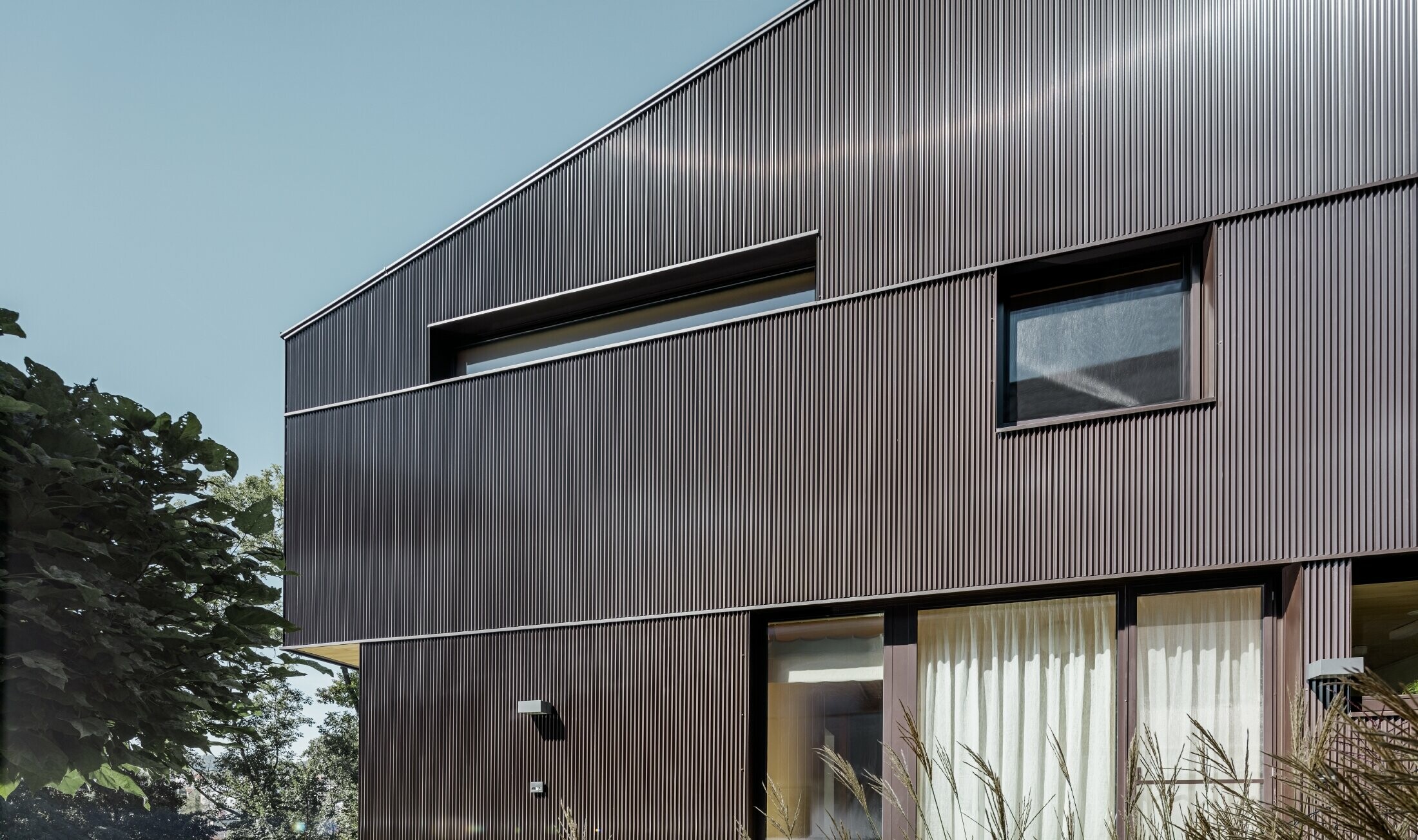 Modern detached house with PREFA zig-zag profile façade cladding in brown.