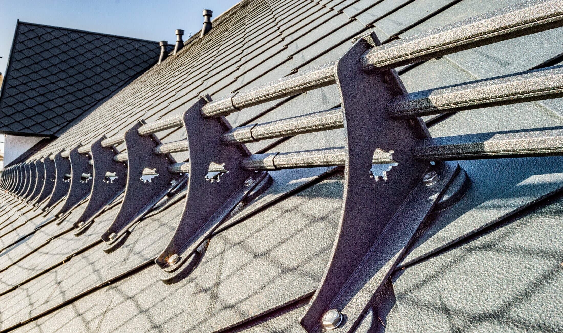 Close-up of the PREFA snow guard system on the PREFA 29 x 29 rhomboid roof tile in anthracite at the Hotel Burg Maienluft.