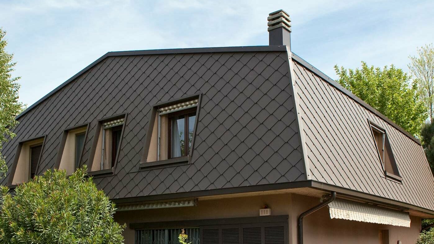 Mansard roof covered with PREFA 29 × 29 rhomboid wall tiles in brown. The upper part of the building was clad with a combination of horizontal larch wood panels and PREFA Siding.X aluminium panels in anthracite.