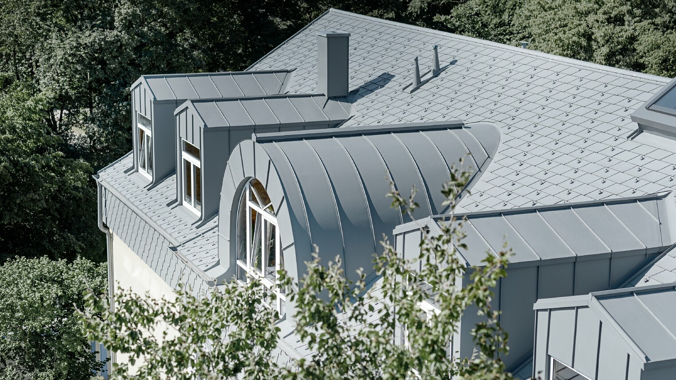Top floor of the Albertinum in Munich with PREFA roof shingles and standing seam in light grey