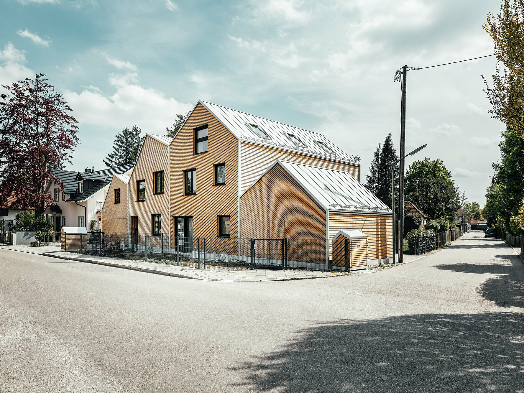 Lateral street view of the semi-detached house "Hausfuchs" ("house fox"), white PREFA roofs with Prefalz sheets, IFUB*