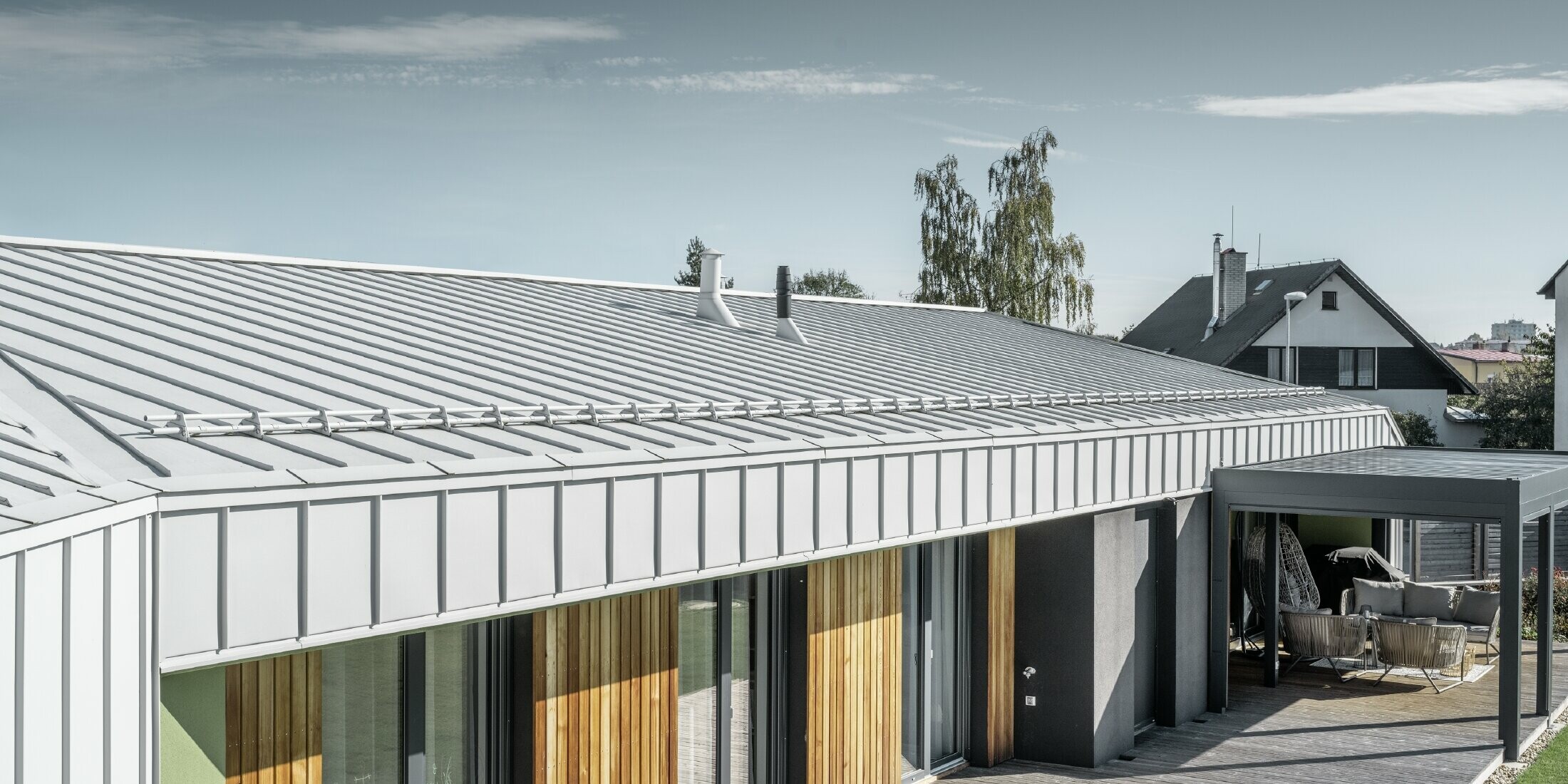 Bungalow with PREFALZ roof and façade in PREFA white and wooden terrace